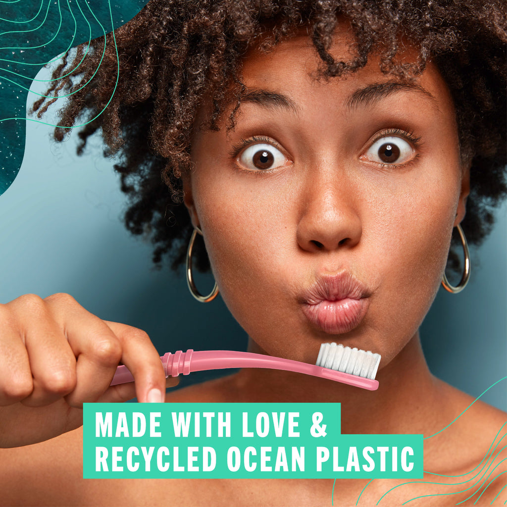 Woman holding a coral pink Preserve toothbrush with text 'Made with love & your recycling' on a blue background