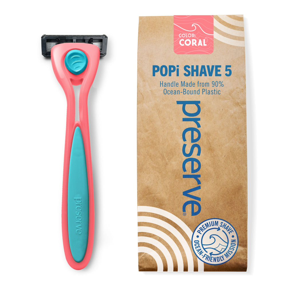 A coral pink Popi Shave 5 razor shown next to its brown paper packaging box on a white background.